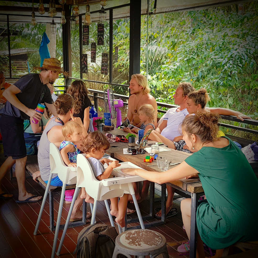 A group of digital nomad families sitting on a restaurant getting to know each other