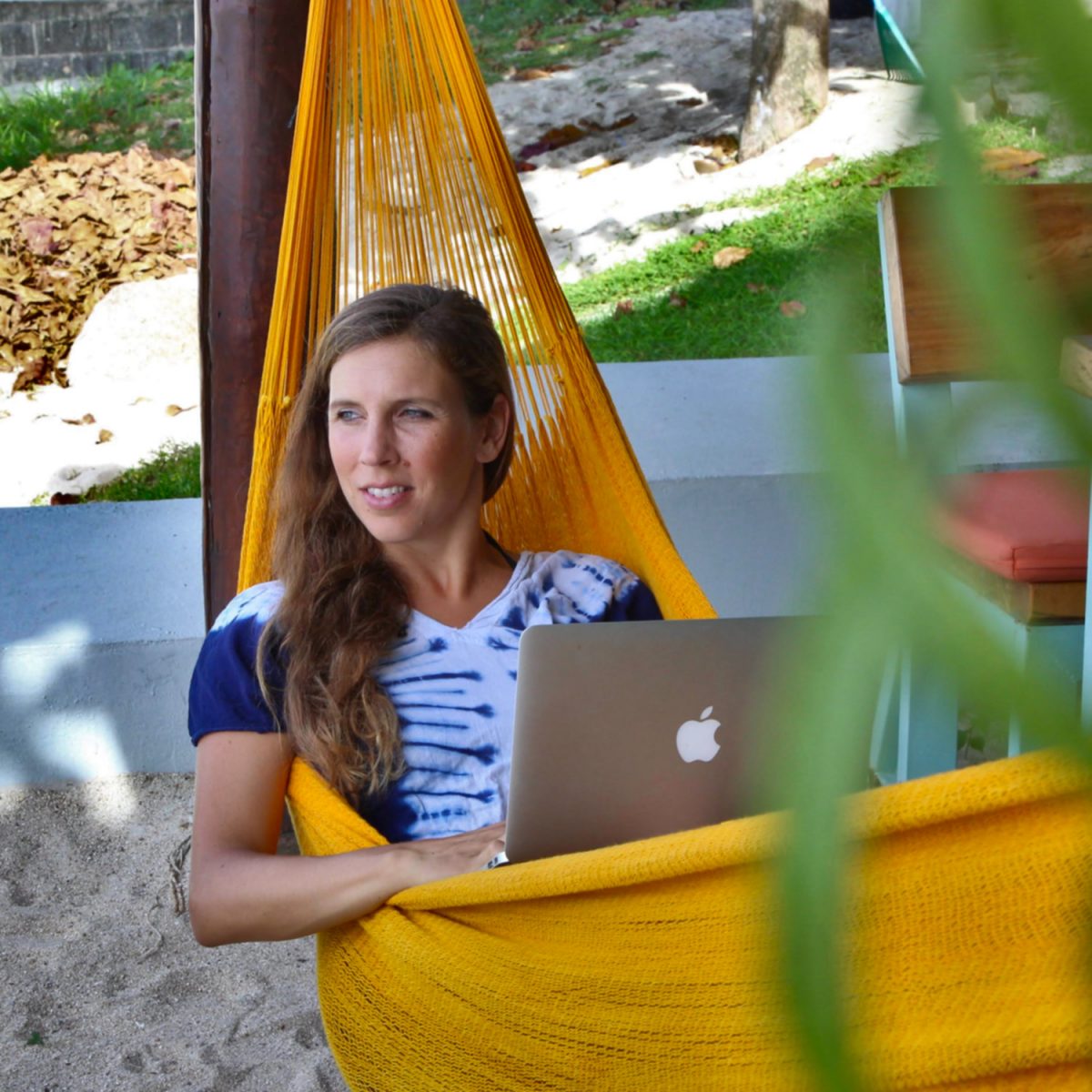 Woman in yellow hammock with her laptop