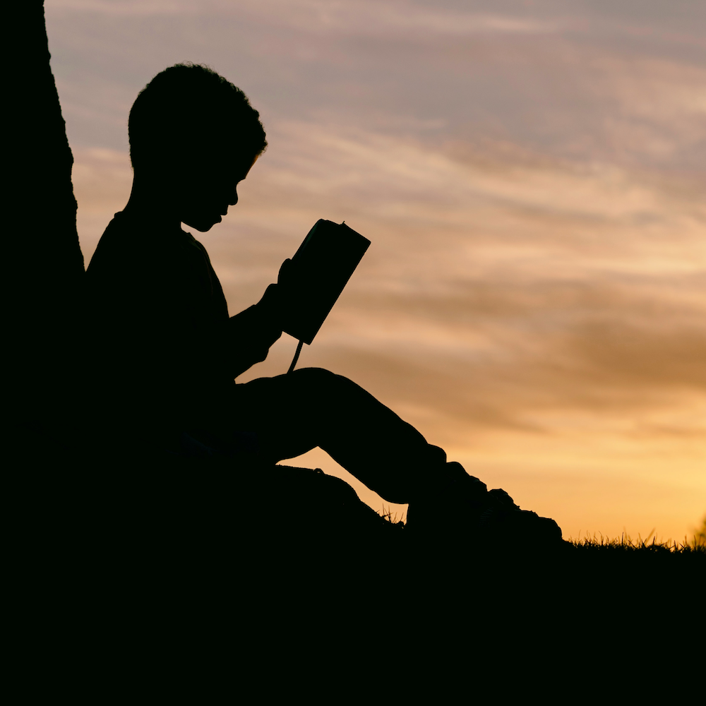 kid reading in nature